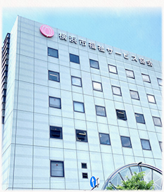 白を基調とした介護施設の建物外観。ピンク色のロゴが目印の多階層建築。