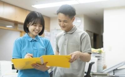 スタッフが入居者に書類やタブレットを説明している様子